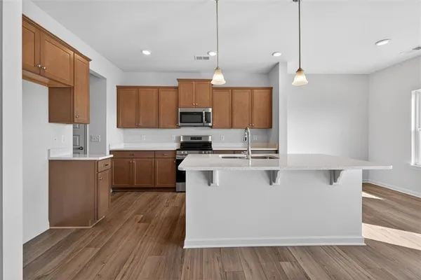 a kitchen with kitchen island wooden floors white cabinets and stainless steel appliances