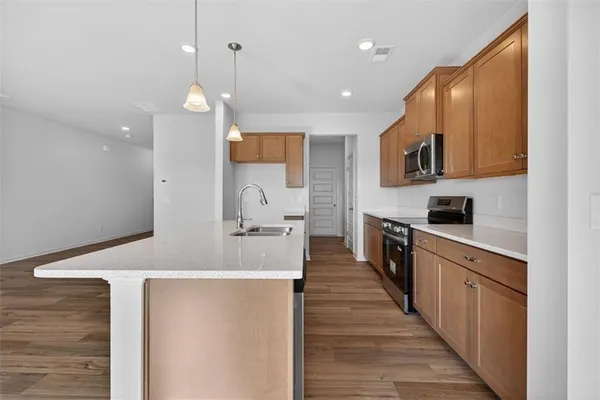 a large kitchen with stainless steel appliances lots of counter space and a sink