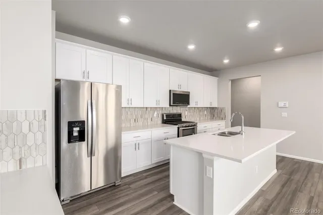 a kitchen with refrigerator cabinets and wooden floor