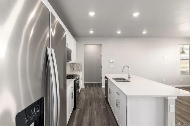 a kitchen with stainless steel appliances granite countertop refrigerator a sink and a stove