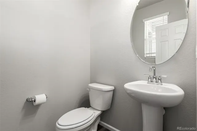 a bathroom with a toilet a sink and mirror