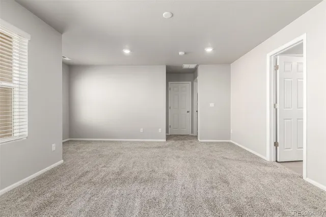 an empty room with windows and closet