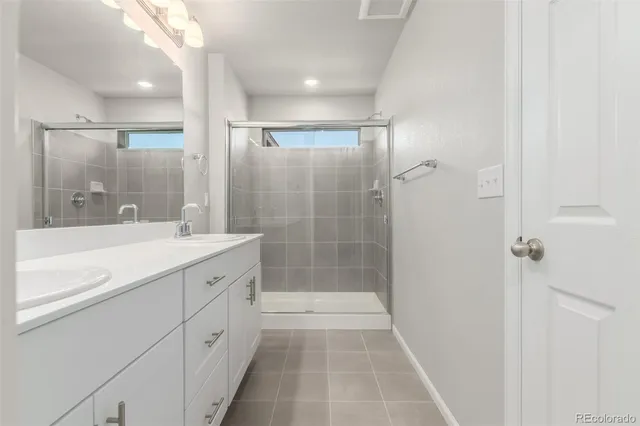 a bathroom with a shower sink and mirror