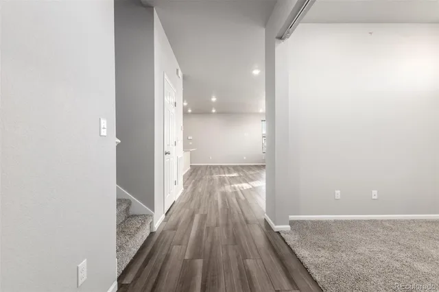 a view of a hallway with wooden floor