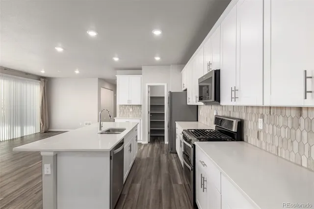 a kitchen with stainless steel appliances kitchen island granite countertop a stove and a sink