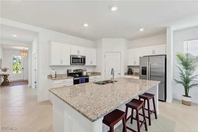 a kitchen with refrigerator and wooden floor