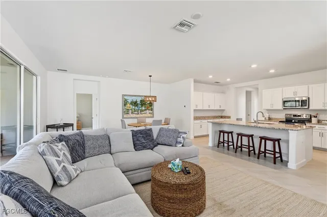 a living room with furniture kitchen view and a dining table