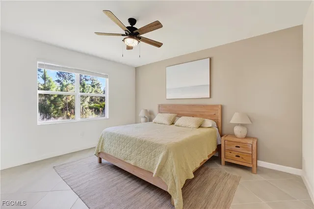 a bedroom with a bed a chandelier and a window
