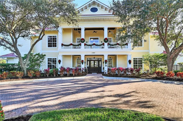 a front view of a house with cars parked and a yard