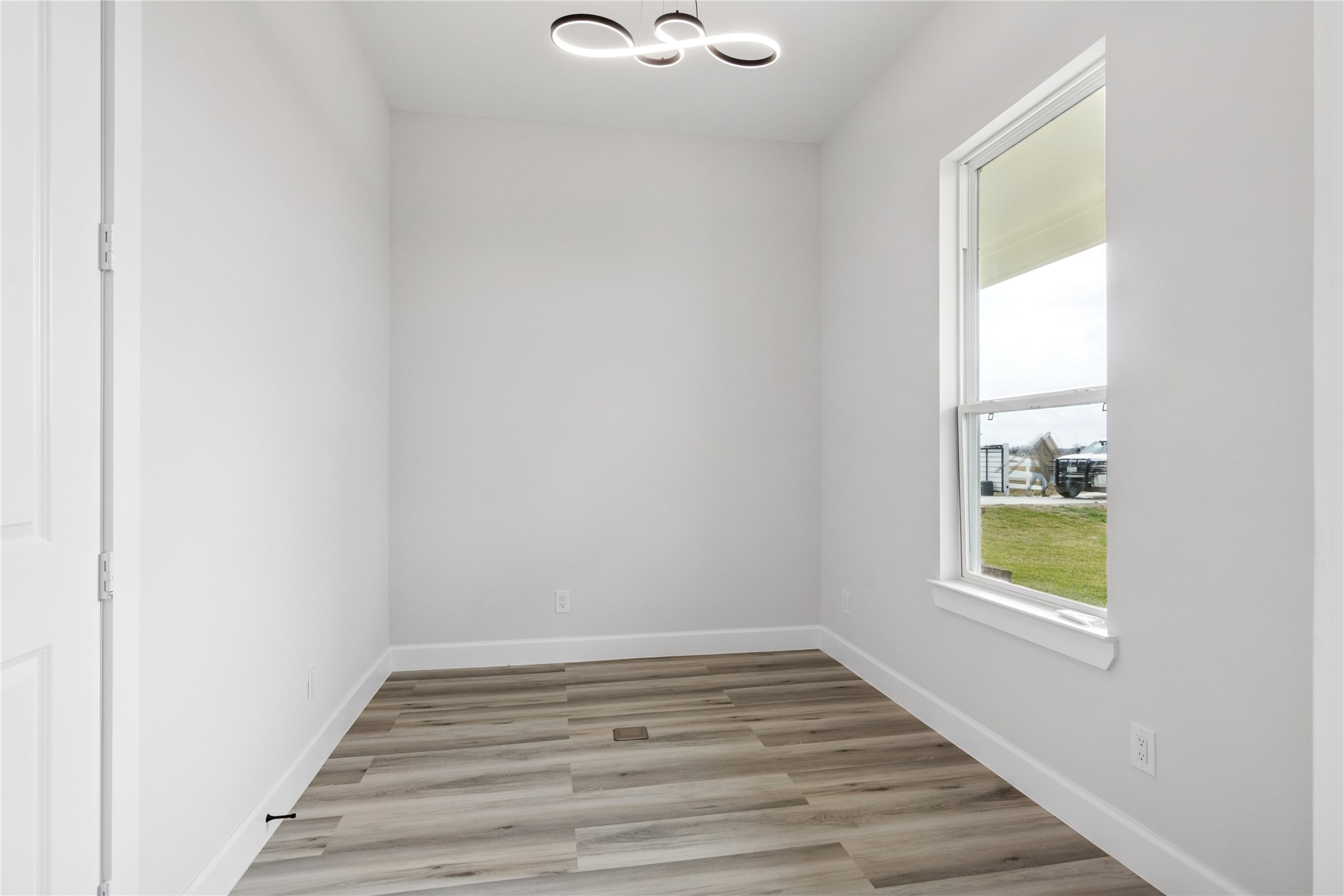 5766 Ward Bend Road Sealy, TX 77474 - Photo 19 of 45 a view of an empty room with wooden floor and a window