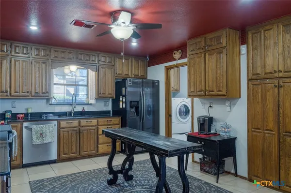 a kitchen with stainless steel appliances granite countertop a stove refrigerator and cabinets