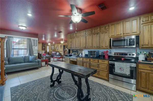 a kitchen with kitchen island granite countertop lots of counter top space and stainless steel appliances