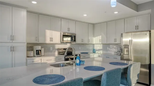 a kitchen with kitchen island a sink appliances and cabinets