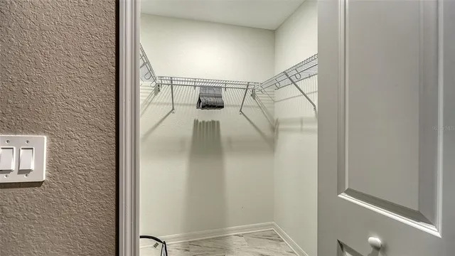 view of a pool with lawn chairs and plants