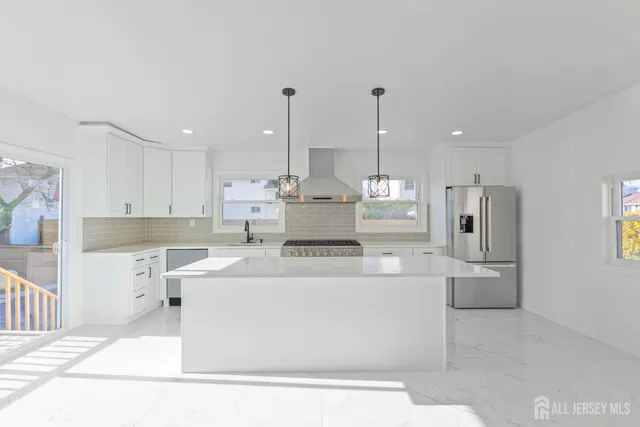 a large white kitchen with stainless steel appliances