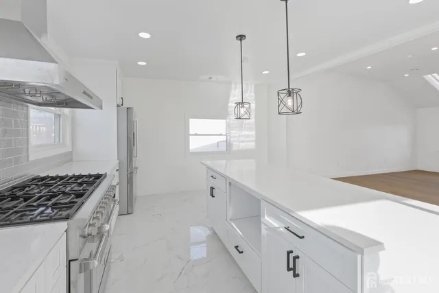 a kitchen with white cabinets and stove