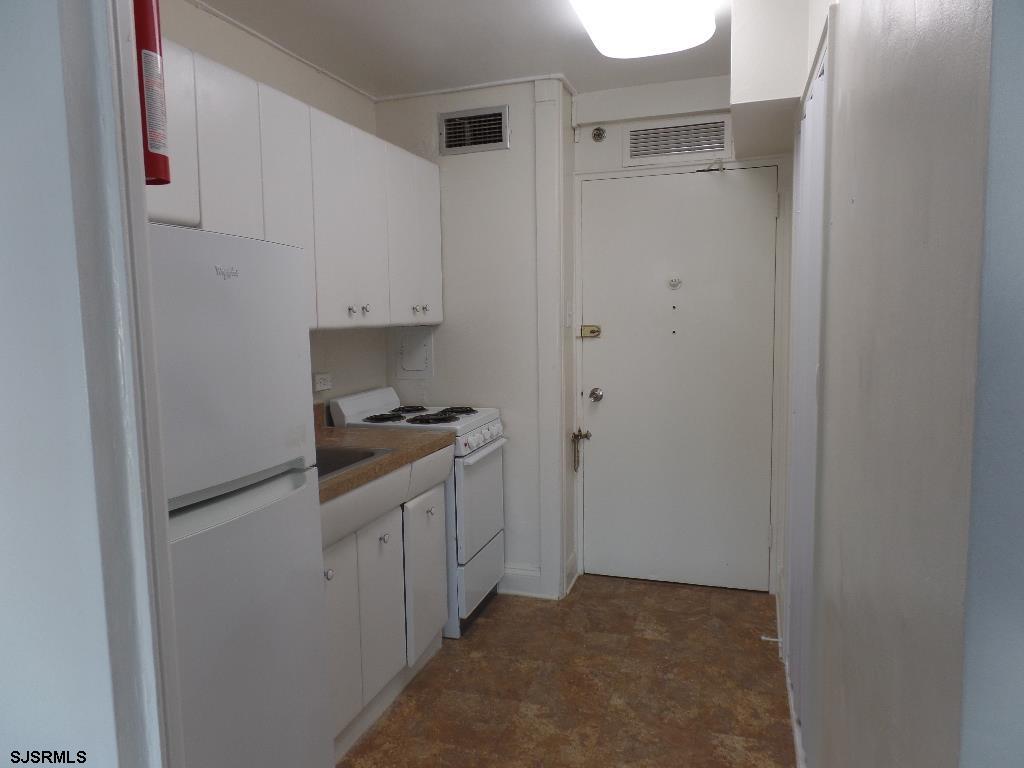 101 South Raleigh Avenue, Unit 221 Atlantic City, NJ 08401 - Photo 6 of 14 a kitchen with a refrigerator and white cabinets