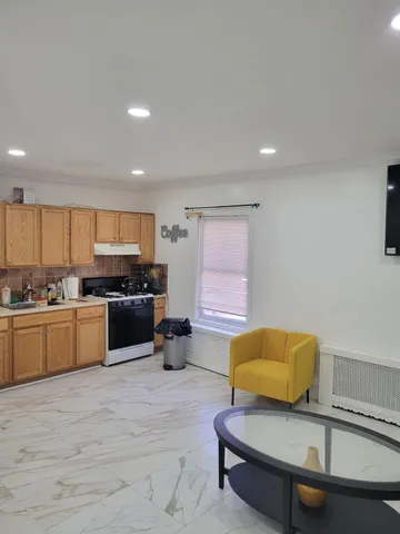 a living room with furniture and kitchen view