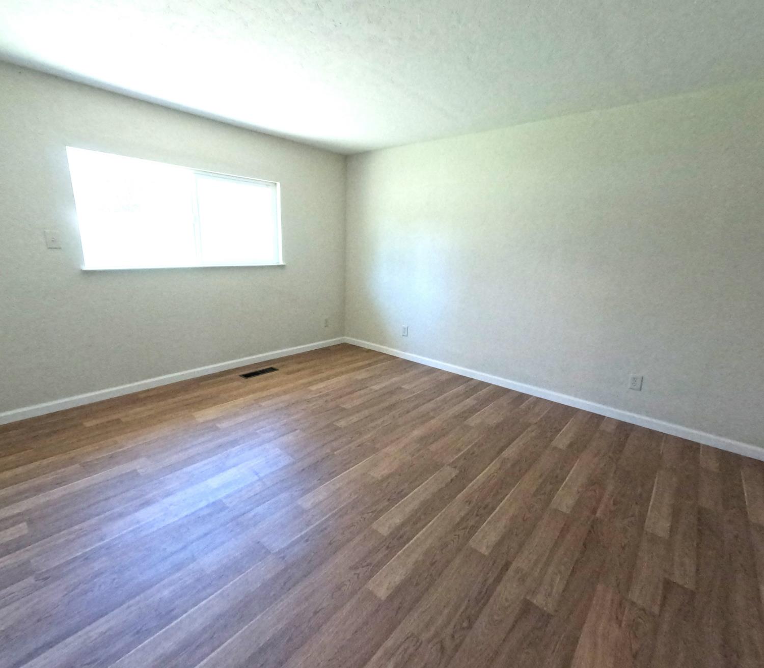 21665 Manton School Road Manton, CA 96059 - Photo 9 of 30 an empty room with wooden floor and windows