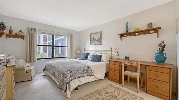 a spacious bedroom with a bed and a chandelier
