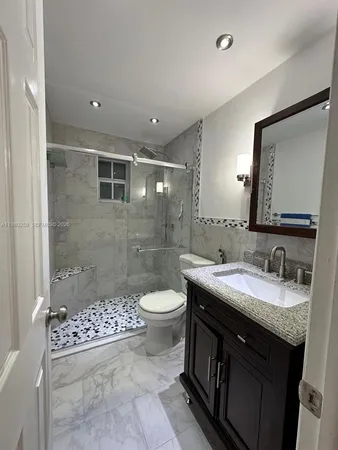 a bathroom with a sink a toilet and shower