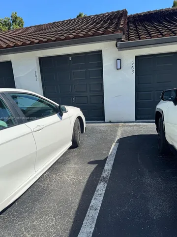 a view of a patio with a table and chairs under an umbrella