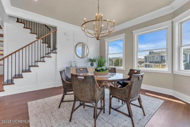 a kitchen with stainless steel appliances granite countertop a stove top oven a dining table and chairs with wooden floor