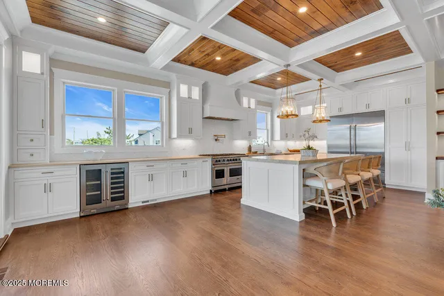 a kitchen with stainless steel appliances granite countertop a sink a window and chairs