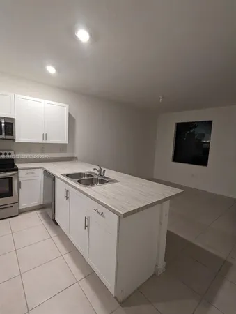 a kitchen with a stove sink and cabinets