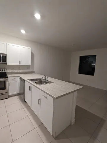 a kitchen with a stove sink and cabinets