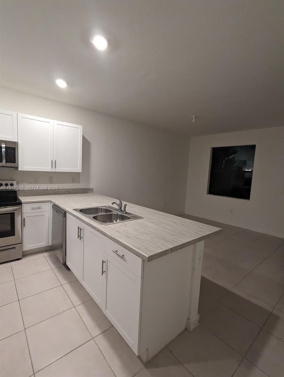 28661 Southwest 132nd Place Homestead, FL 33033 - Photo 11 of 16 a kitchen with a stove sink and cabinets