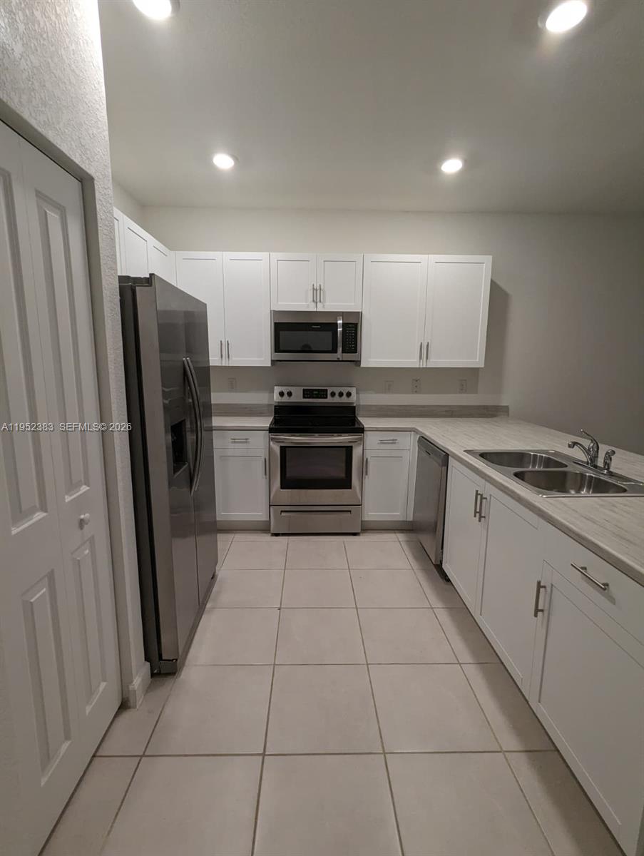 28661 Southwest 132nd Place Homestead, FL 33033 - Photo 12 of 16 a kitchen with stainless steel appliances granite countertop a refrigerator and a stove top oven