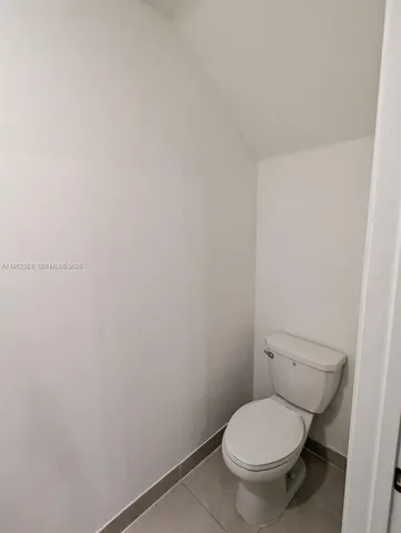 a white toilet sitting next to a white wall