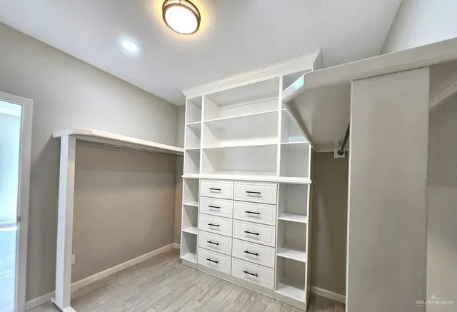 a view of walk in closet with empty racks
