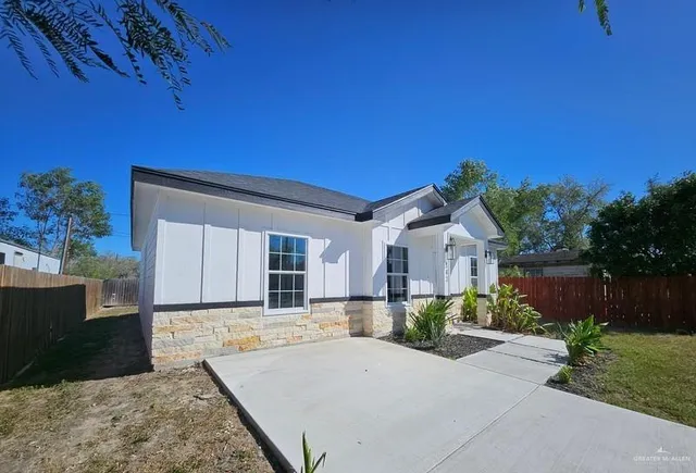 a front view of a house with a yard and potted plants
