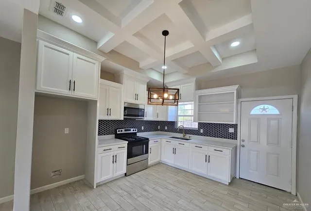 a kitchen with granite countertop a sink cabinets and stainless steel appliances