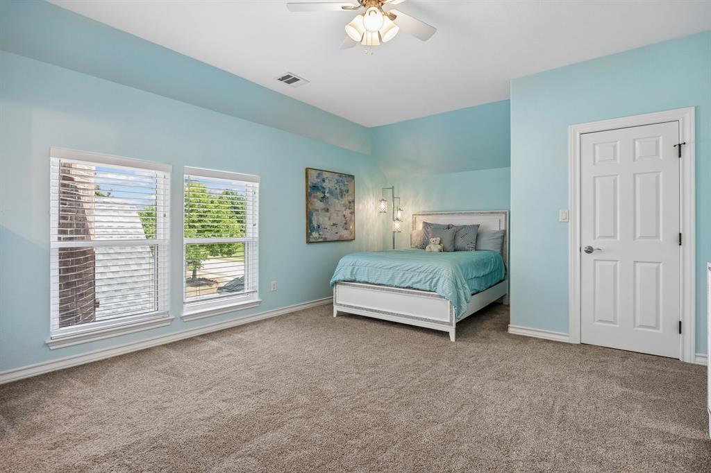 1011 Three Rivers Drive Prosper, TX 75078 - Photo 18 of 27 a spacious bedroom with a bed and a chandelier