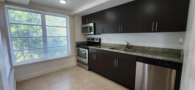 a kitchen with granite countertop a sink and a stove