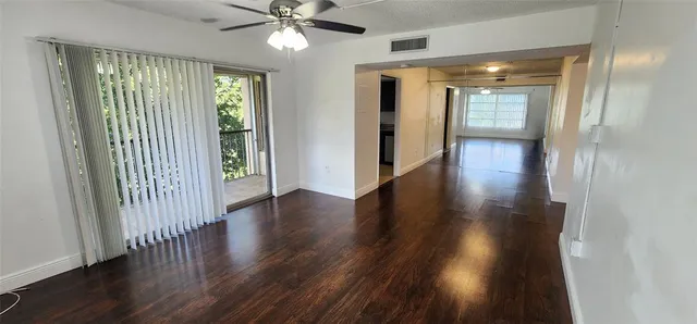 a view of a hallway with wooden floor and closet