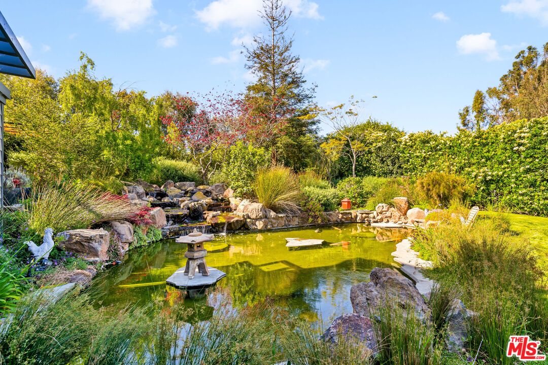 28850 Hampton Place Malibu, CA 90265 - Photo 54 of 58 a view of a swimming pool with lawn chairs under an umbrella