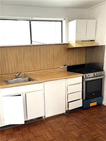 a kitchen with granite countertop white cabinets and white appliances