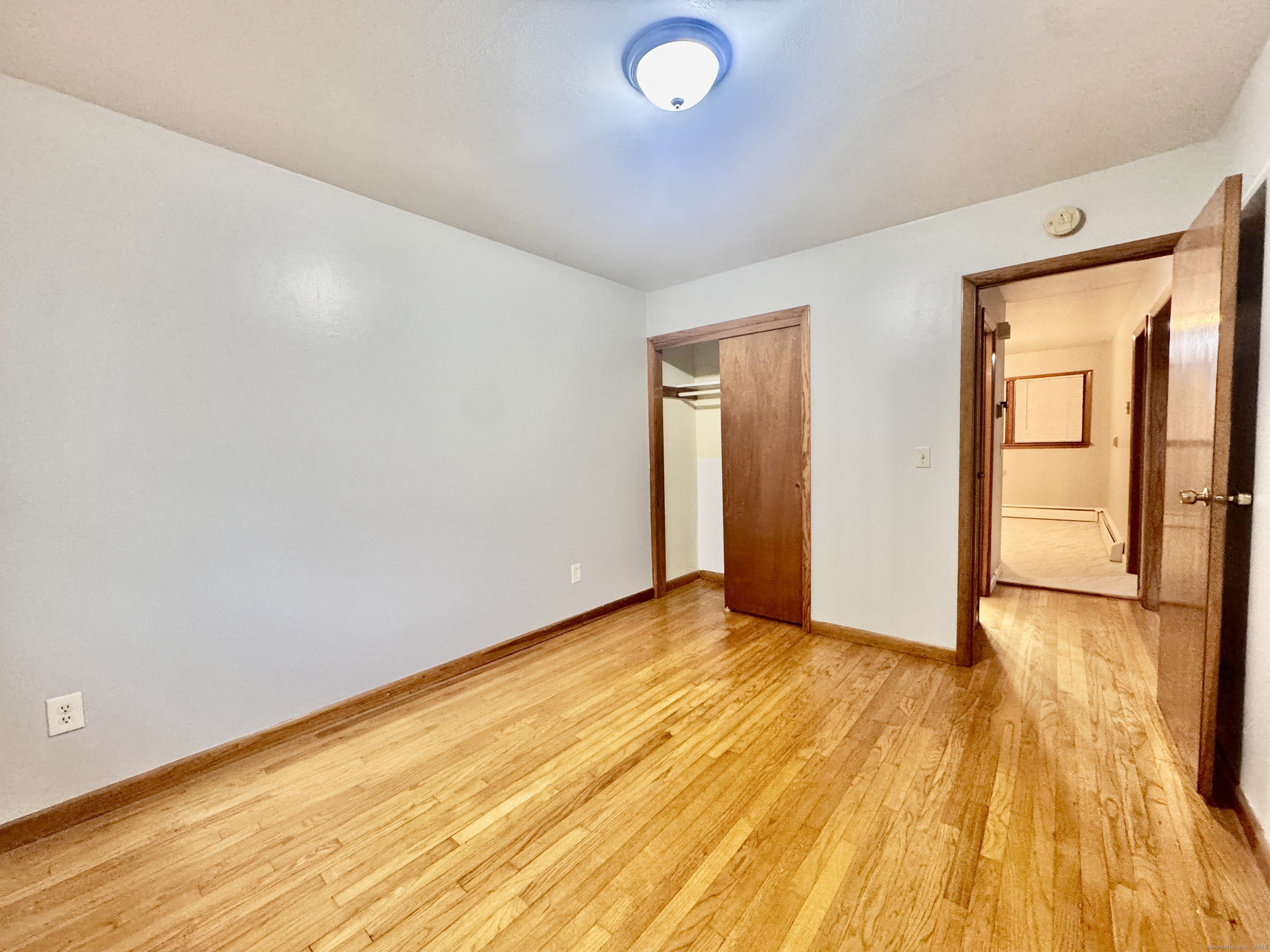 197 Potuccos Ring Road, Unit 5 Wolcott, CT 06716 - Photo 12 of 19 an empty room with wooden floor and windows