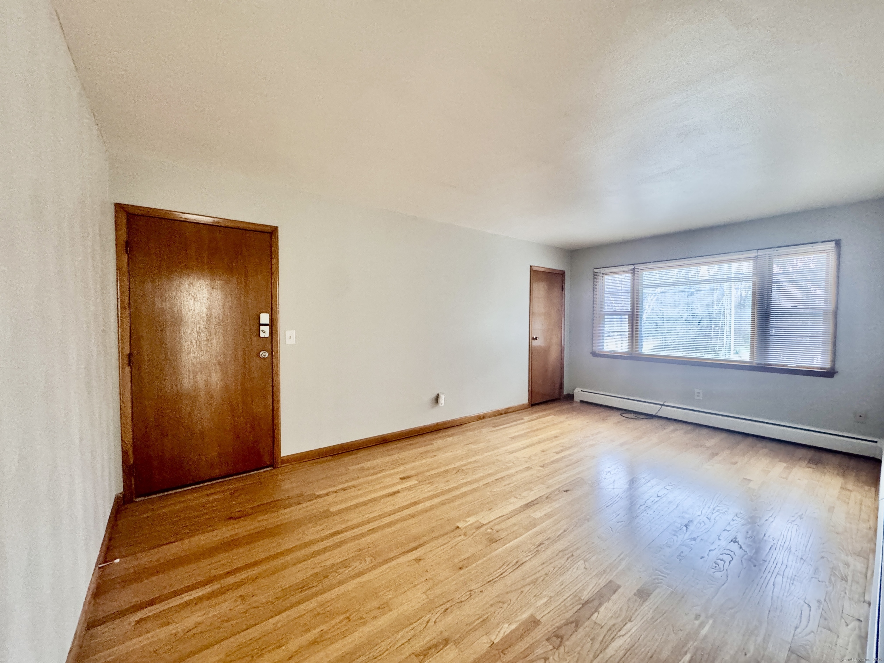 197 Potuccos Ring Road, Unit 5 Wolcott, CT 06716 - Photo 4 of 19 a view of an empty room with wooden floor and a window