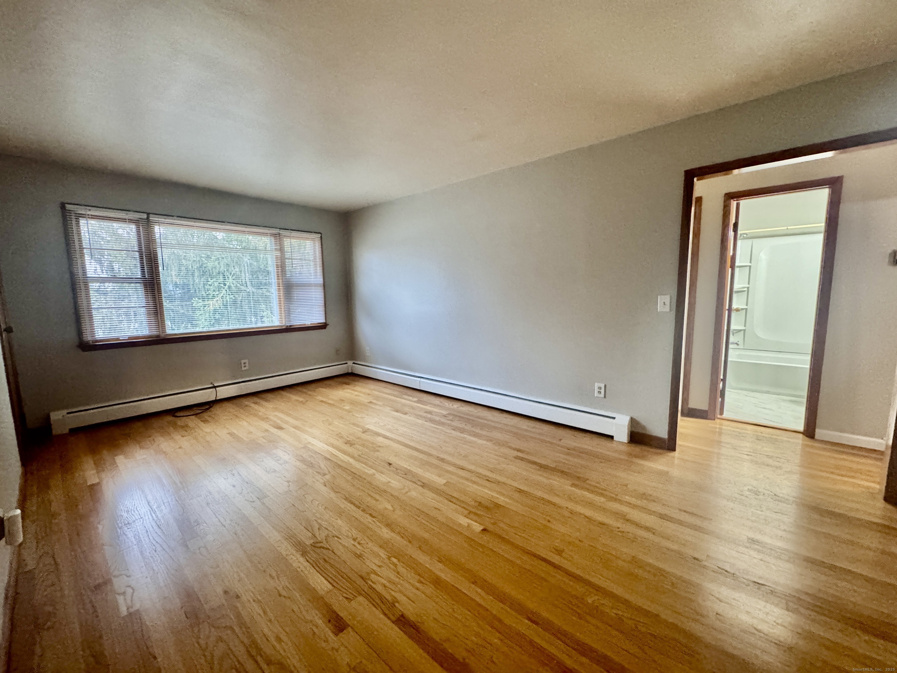 197 Potuccos Ring Road, Unit 5 Wolcott, CT 06716 - Photo 5 of 19 an empty room with wooden floor and windows