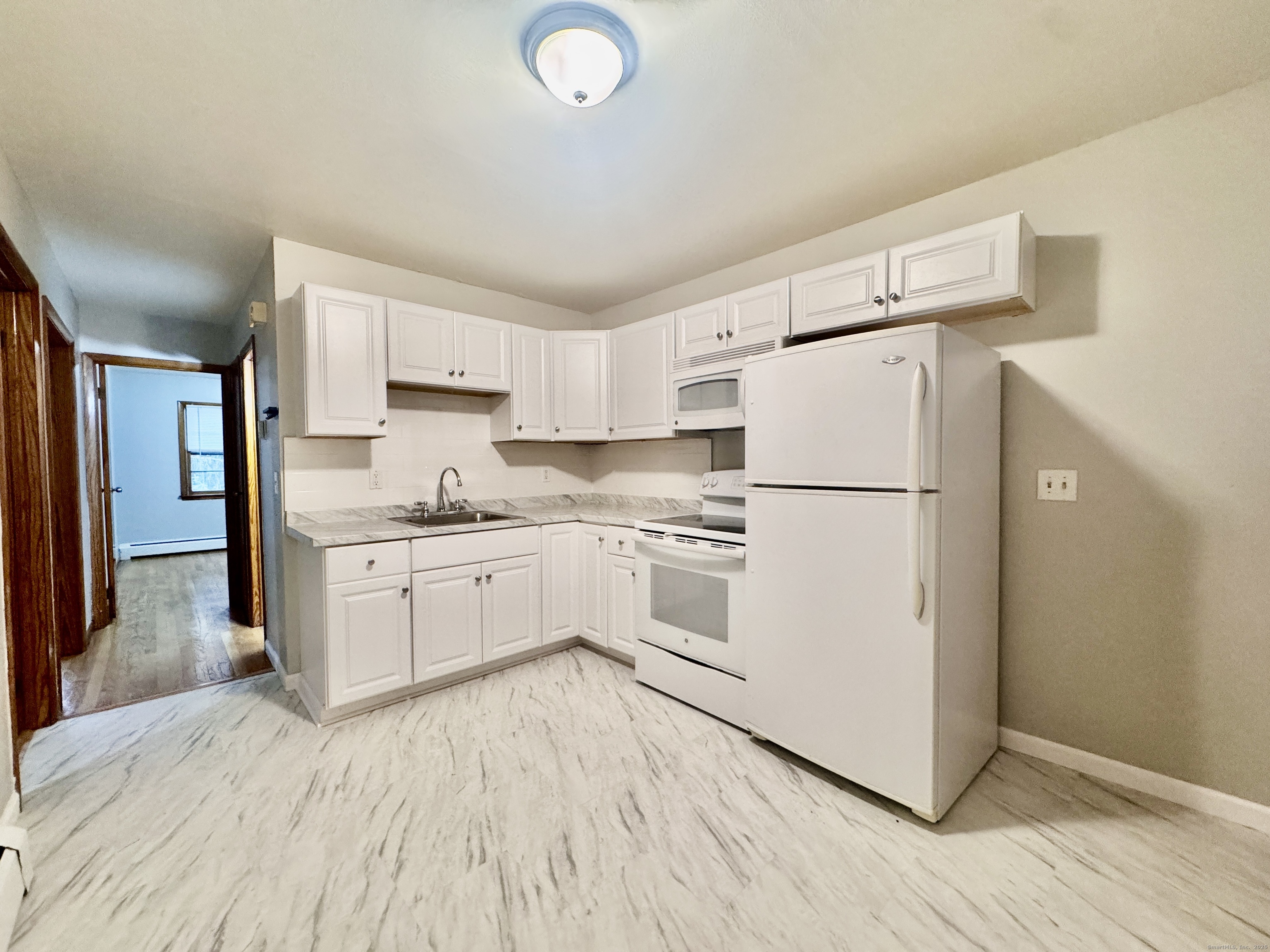 197 Potuccos Ring Road, Unit 5 Wolcott, CT 06716 - Photo 9 of 19 a kitchen with white cabinets and white appliances