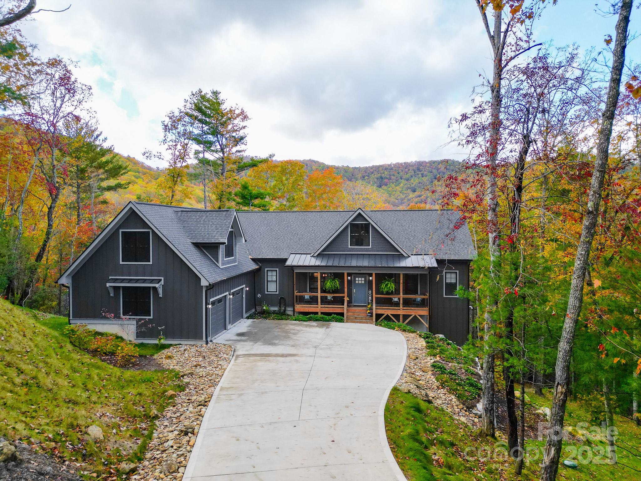 a view of a house with a big yard plants and large tree