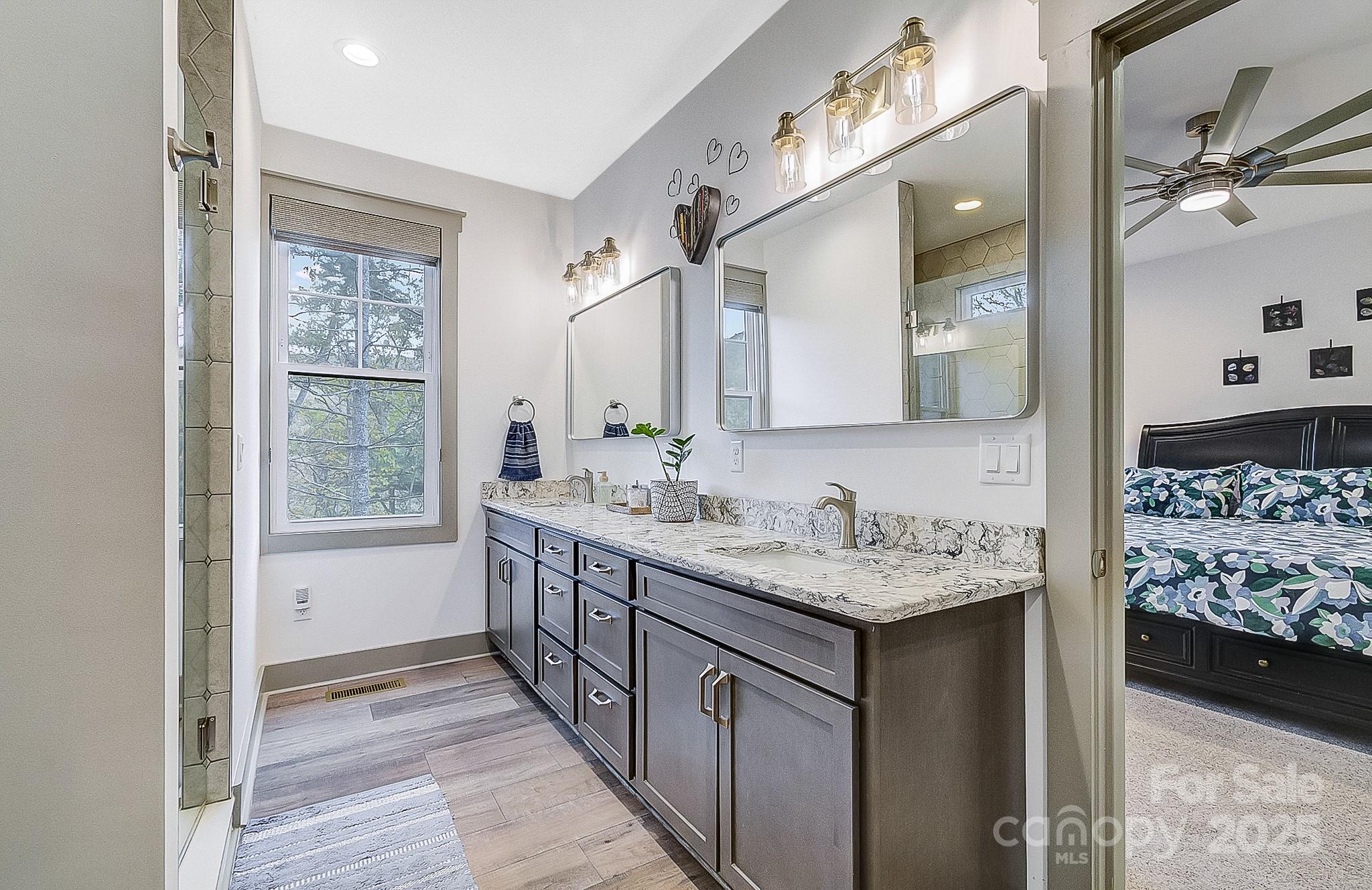 250 Judson Ridge Road Arden, NC 28704 - Photo 33 of 47 a bathroom with a granite countertop sink and a mirror