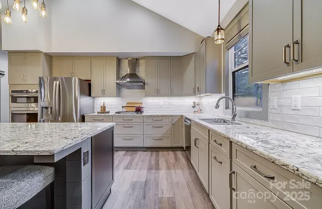 a kitchen with granite countertop a sink cabinets and wooden floor