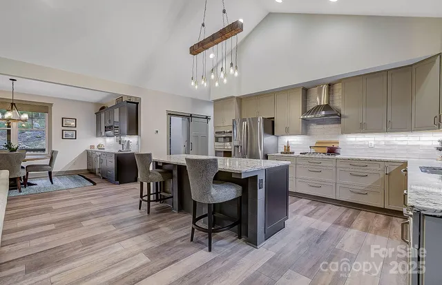 a living room with furniture kitchen view and a chandelier