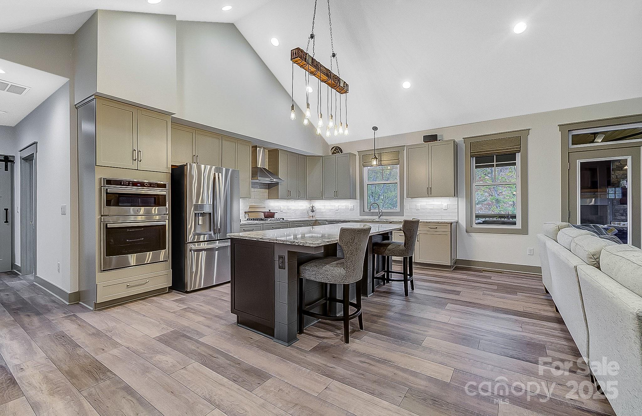 250 Judson Ridge Road Arden, NC 28704 - Photo 5 of 47 a kitchen with stainless steel appliances a dining table chairs stove refrigerator and cabinets